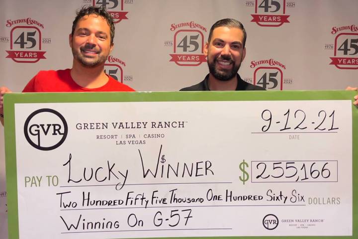 Bingo supervisor Javier, left, and bingo agent Chad present a $255,166 Jumbo Check to an anonym ...