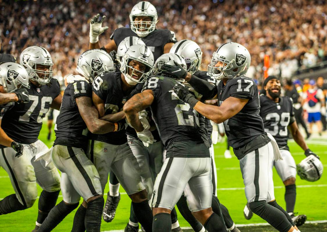 Raiders players celebrate their win in overtime during their season-opener against the Baltimor ...