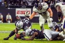 Raiders defensive tackle Darius Philon (96) picks up a fumble with teammate Raiders defensive e ...