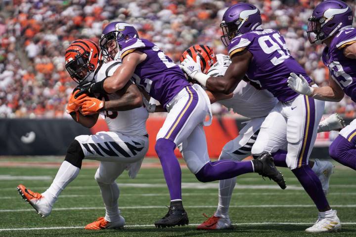 Cincinnati Bengals running back Joe Mixon, left, is tackled by Minnesota Vikings free safety Ha ...