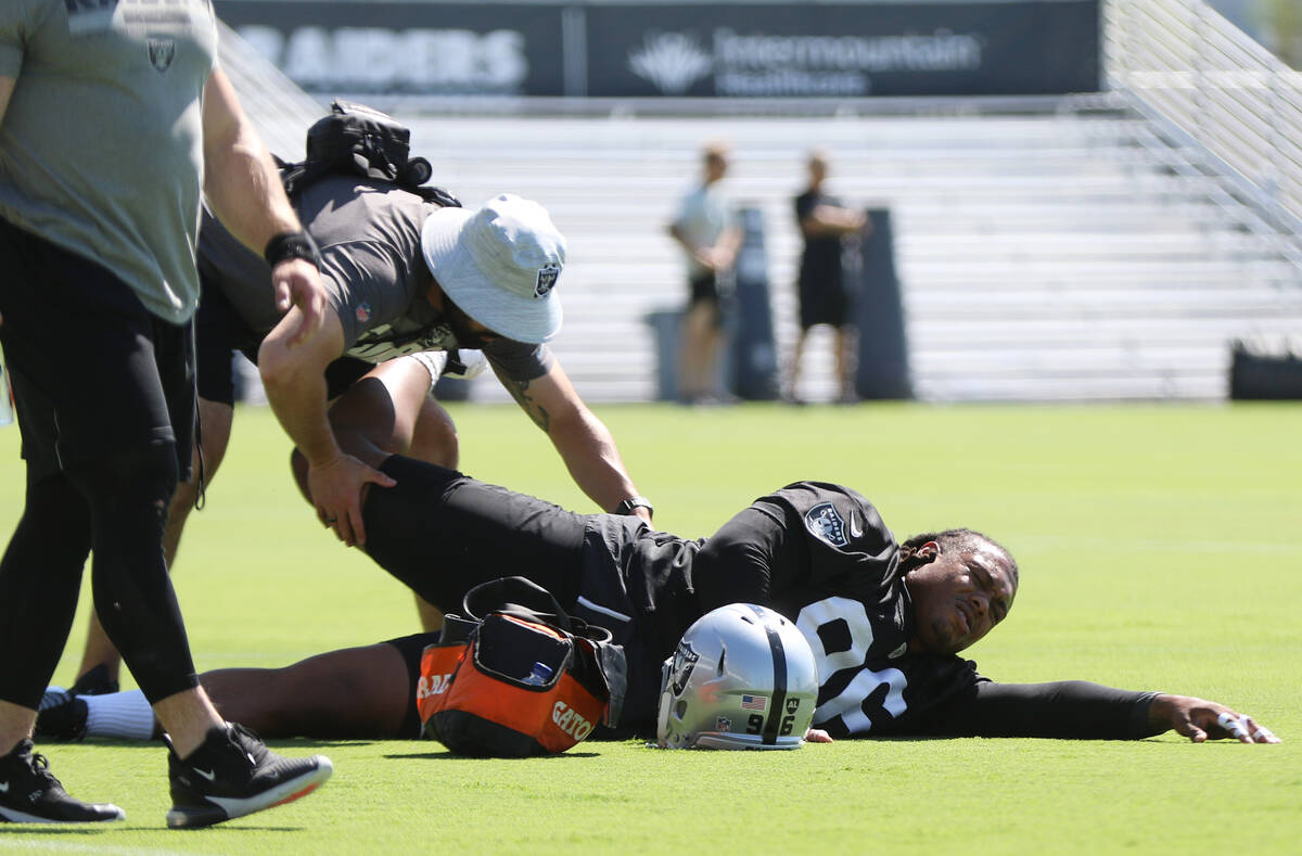 A trainer works on Raiders defensive tackle Darius Philon (96) who suffered an injury during te ...