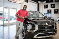 UFC Heavyweight Champion Francis Ngannou stands in front of the 2022 Outlander at Johnny Legend ...
