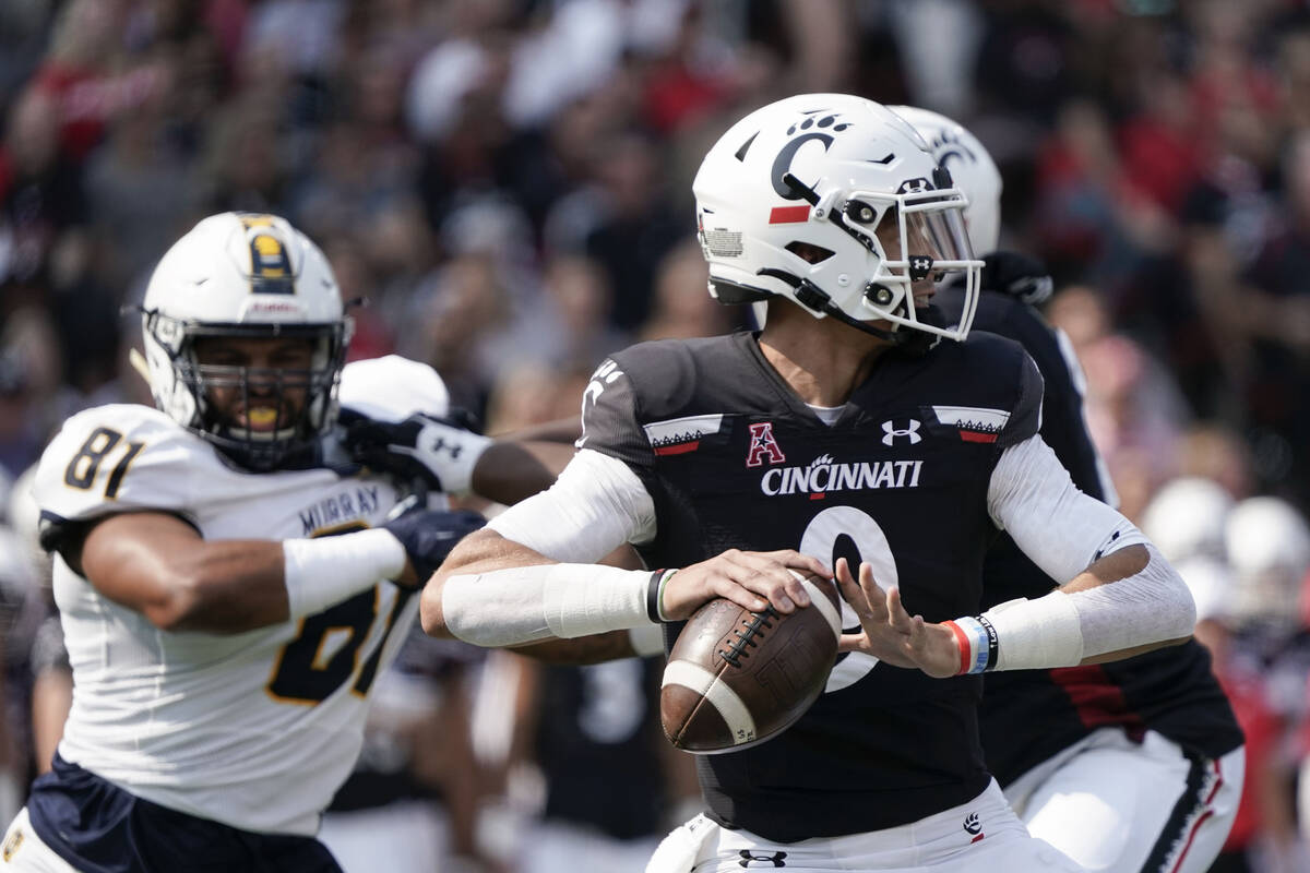 Cincinnati quarterback Desmond Ridder, center, drops back for a pass during the first half of a ...