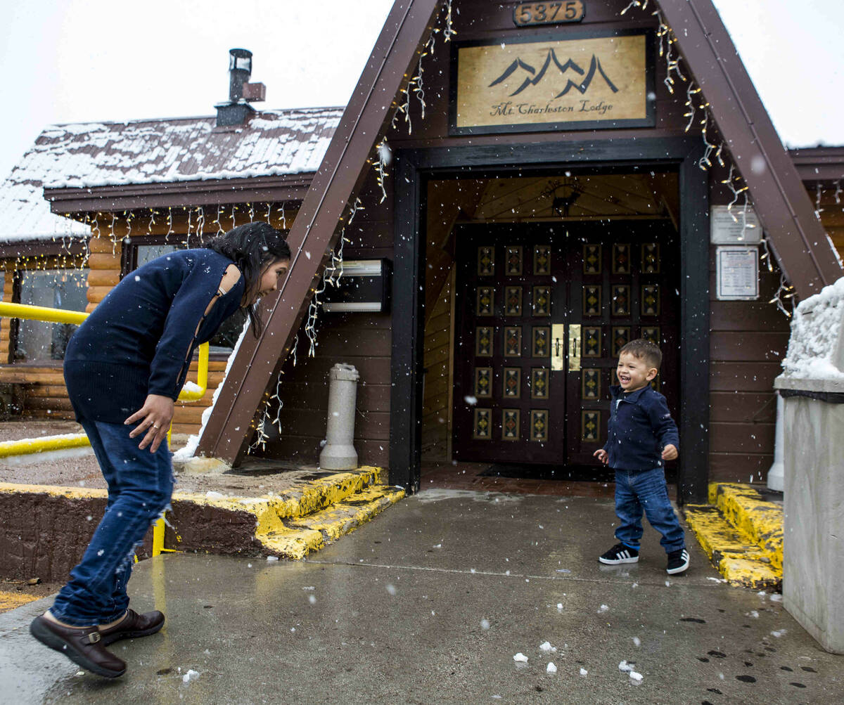 Nofi Simanungkalit and her son, David, 2, enjoy snow outside of the Mount Charleston Lodge on T ...