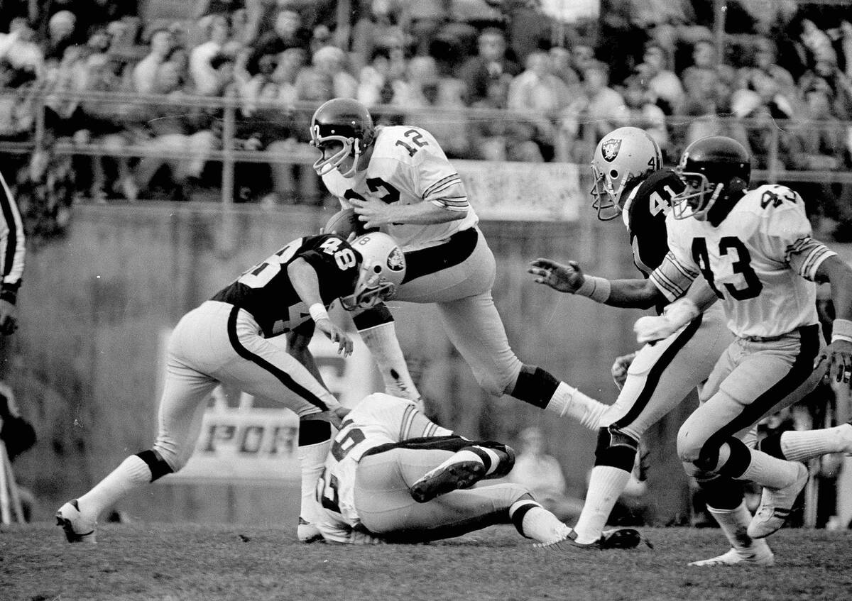 Pittsburgh Steelers querterback Terry Bradshaw (12) packs the ball for a three yard gain in the ...