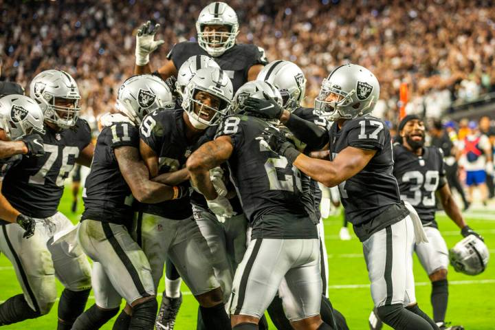 Raiders players celebrate their win in overtime during their season-opener against the Baltimor ...