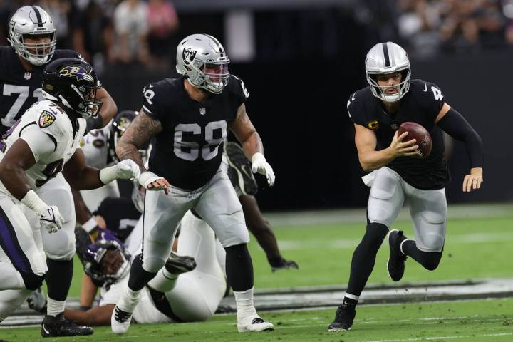 Raiders quarterback Derek Carr (4) carries a ball against Baltimore Ravens during the first qua ...