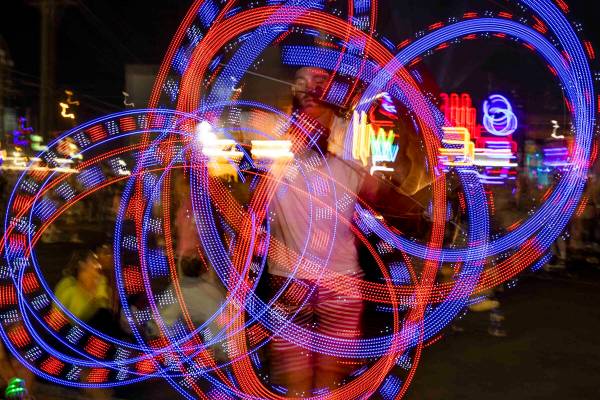 Matt Warnock of Las Vegas twirls some LED sticks during day one of Life is Beautiful on Friday, ...