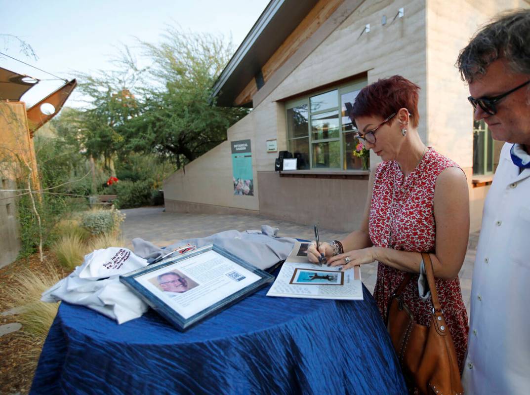 Kelly Slaughter of Las Vegas writes a message on a book when she and her husband Kevin arrive a ...