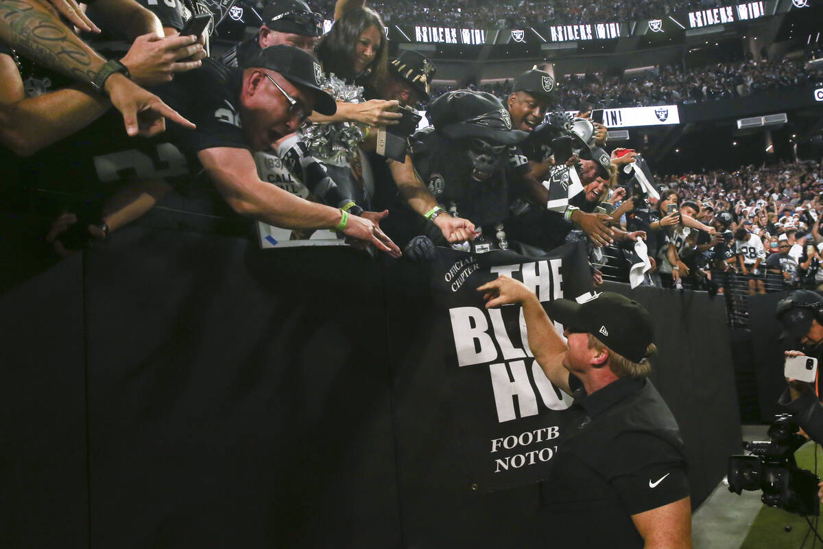 Raiders head coach Jon Gruden celebrates with fans in the black hole after an overtime win agai ...
