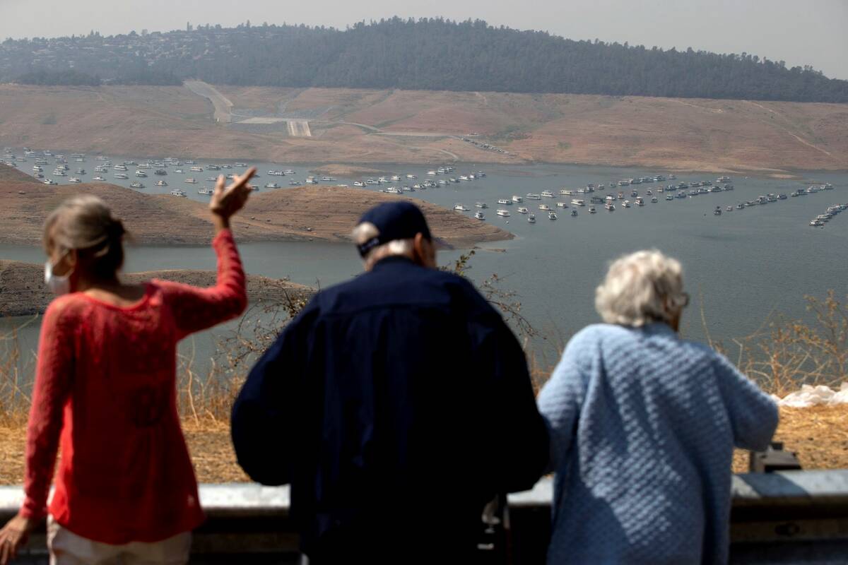 Visitors look out over Lake Oroville as water levels remain low due to continuing drought condi ...