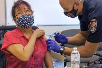 Grace Freckman receives a COVID-19 vaccine from Clark County Fire Department engineer and param ...