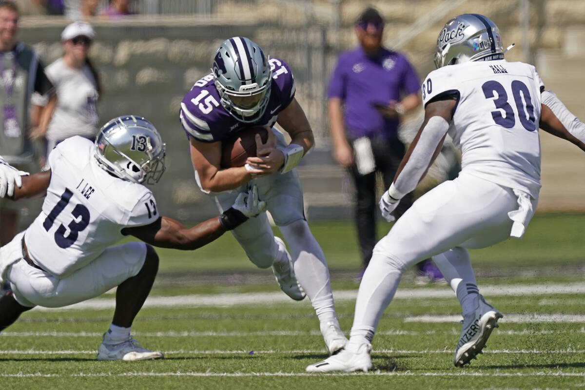 Kansas State quarterback Will Howard (15) runs between Nevada defensive back Jordan Lee (13) an ...