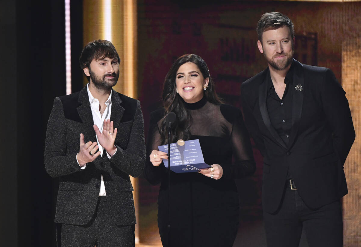 Dave Haywood, from left, Hillary Scott, and Charles Kelley of Lady Antebellum present the award ...