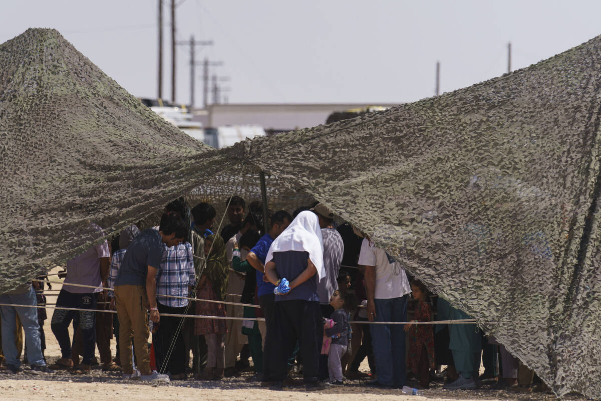 Afghan refugees line up for food outside a dining hall at Fort Bliss' Doña Ana Village where t ...