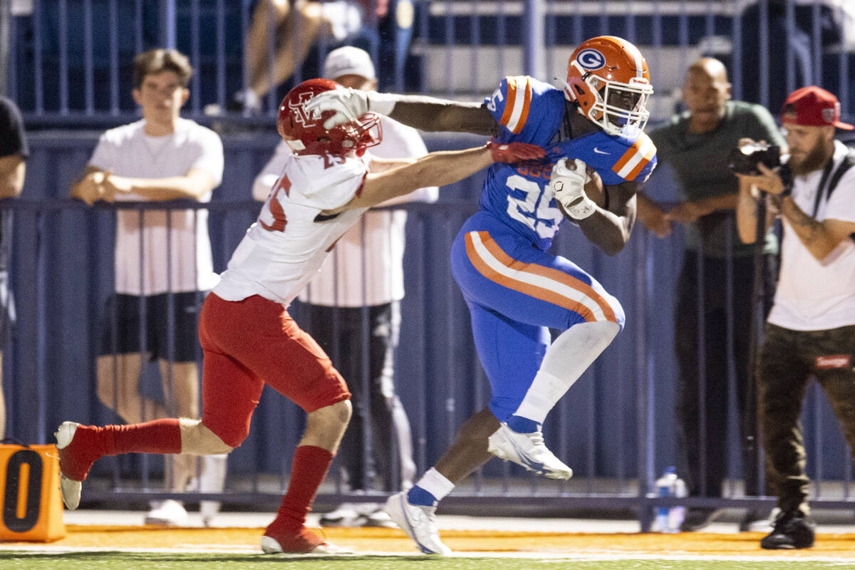 Bishop Gorman's William Stallings Jr (25) runs the ball against Arbor View's Tanner Aitken (25) ...