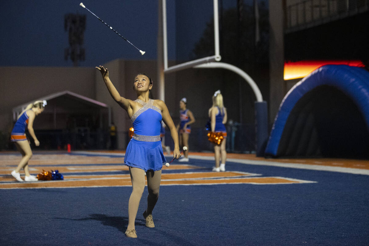 Sophomore Riley Ventura throws a baton before the start of a football game between Bishop Gorma ...