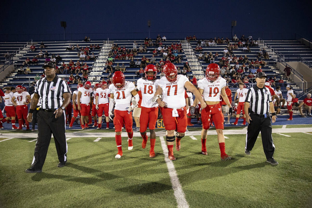 Arbor View's Aiden Powell (21), David Washington (18), Damien Beltran (77) and Jacob Mace (19) ...