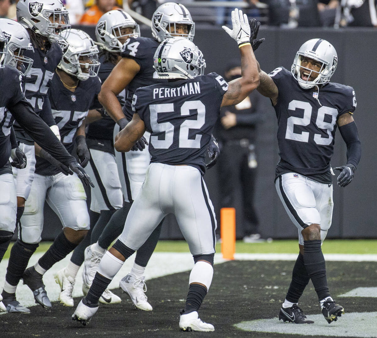 Las Vegas Raiders middle linebacker Denzel Perryman (52) gives a high five to Las Vegas Raiders ...