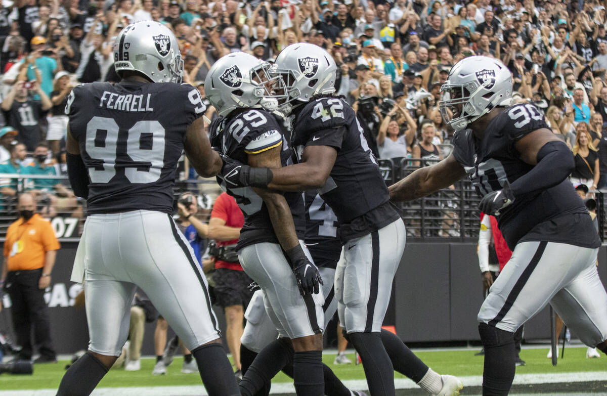 Raiders inside linebacker Cory Littleton (42) embraces Raiders cornerback Casey Hayward (29) af ...