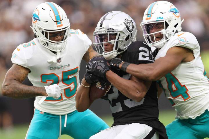 Las Vegas Raiders running back Kenyan Drake (23) is tackled by Miami Dolphins cornerback Xavien ...