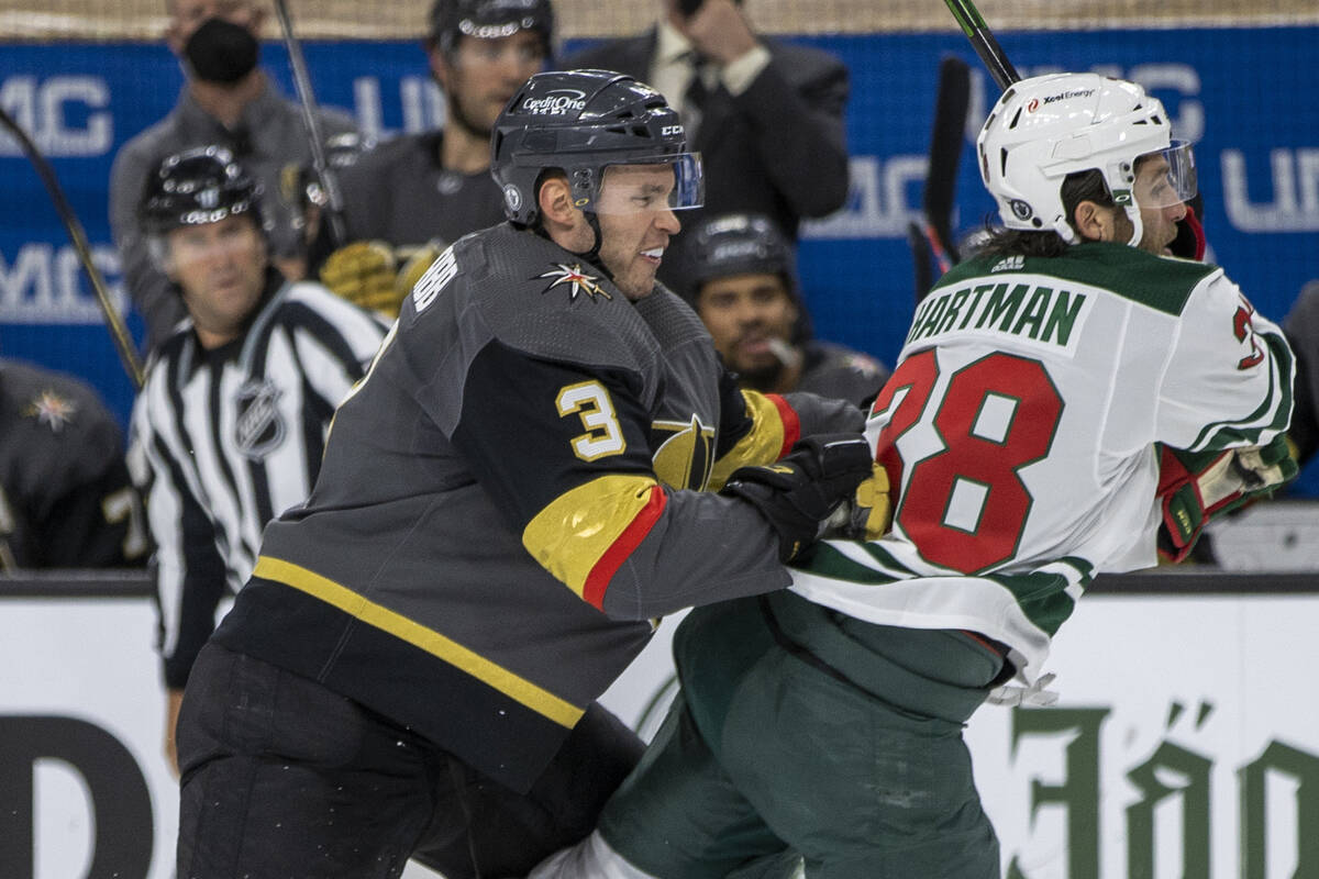 Golden Knights defenseman Brayden McNabb (3) checks Minnesota Wild right wing Ryan Hartman (38) ...