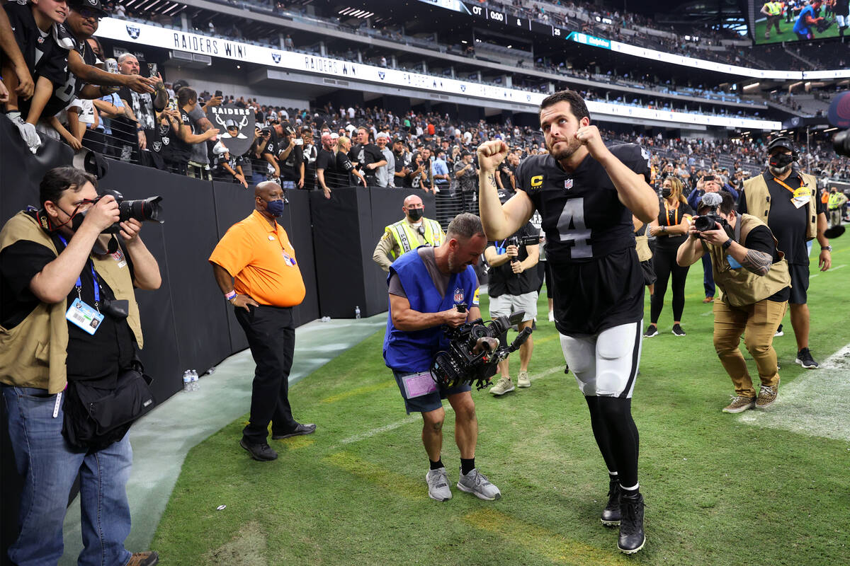 Las Vegas Raiders quarterback Derek Carr (4) raises his arms as he leaves the field after an ov ...