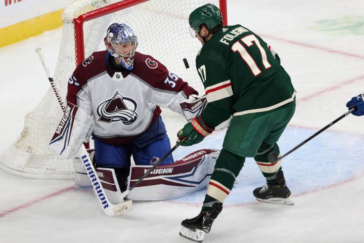 Colorado Avalanche's goalie Darcy Kuemper (35) watches the puck fly in front of Minnesota Wild' ...