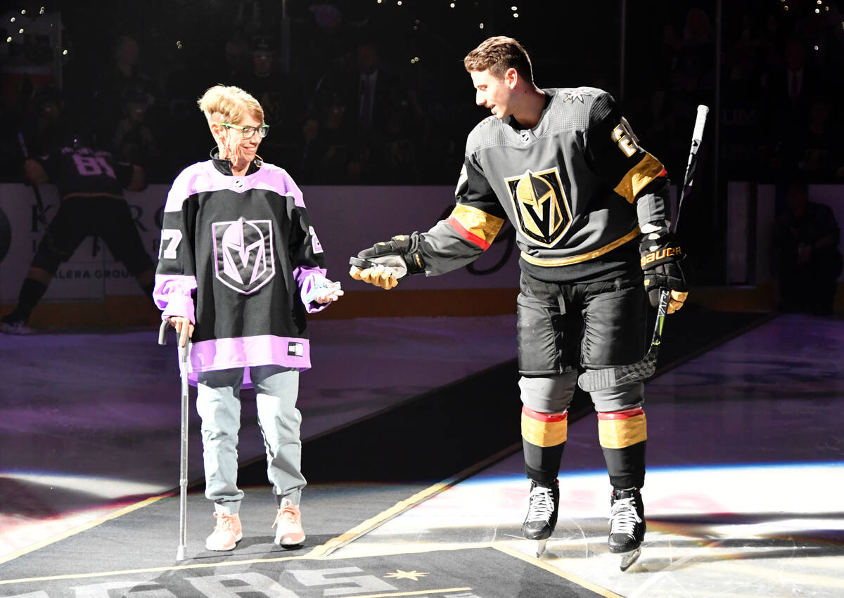 Shea Theodore of the Vegas Golden Knights escorts his grandmother, Kay Darlington, to center ic ...