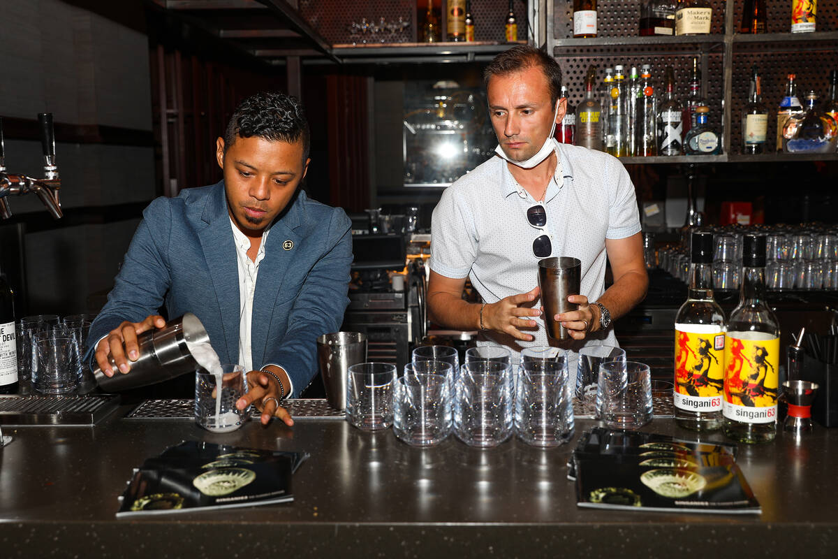 Ricky Lin, director of sales for Singani 63, left, pours a cocktail alongside Enis Kola, direct ...