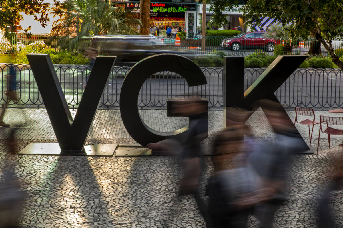 Fans stream by a VGK logo on Las Vegas Blvd. before the start of Game 4 of an NHL Western Confe ...