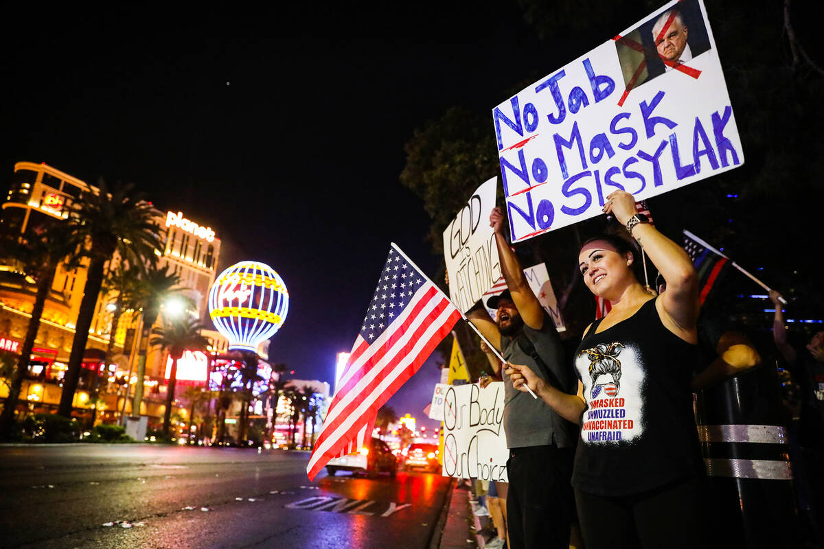 Juliana Mendoza holds a sign protesting COVID-19 government mandates and Gov. Sisolak, for a pr ...