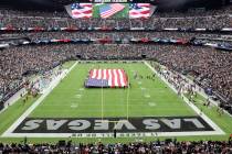 Fans listen to Brian Flores, grandson of Raiders alumnus Tom Flores, sing the National Anthem b ...