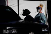 FILE - In this July 10, 2020, file photo, healthcare workers test patients in their cars at a d ...