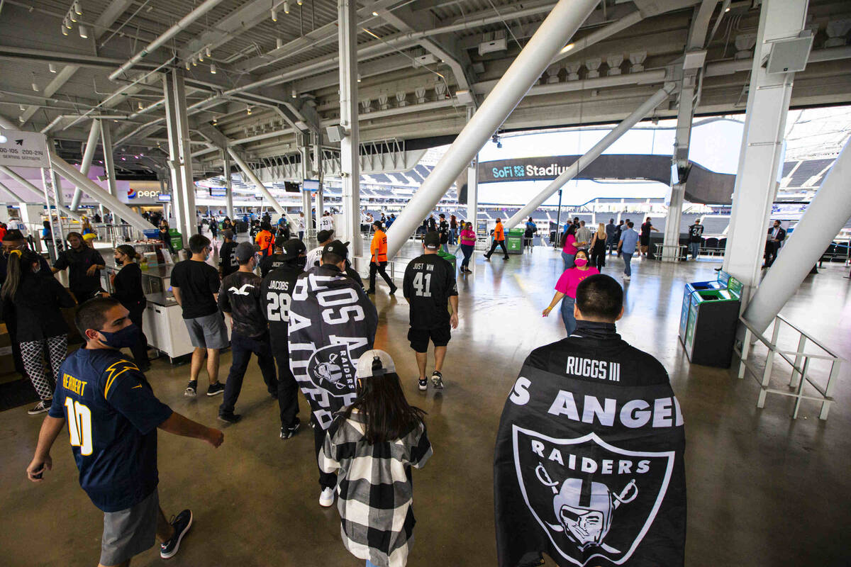 Raiders fans walk around SoFi Stadium before the start of an NFL game against the Los Angeles C ...