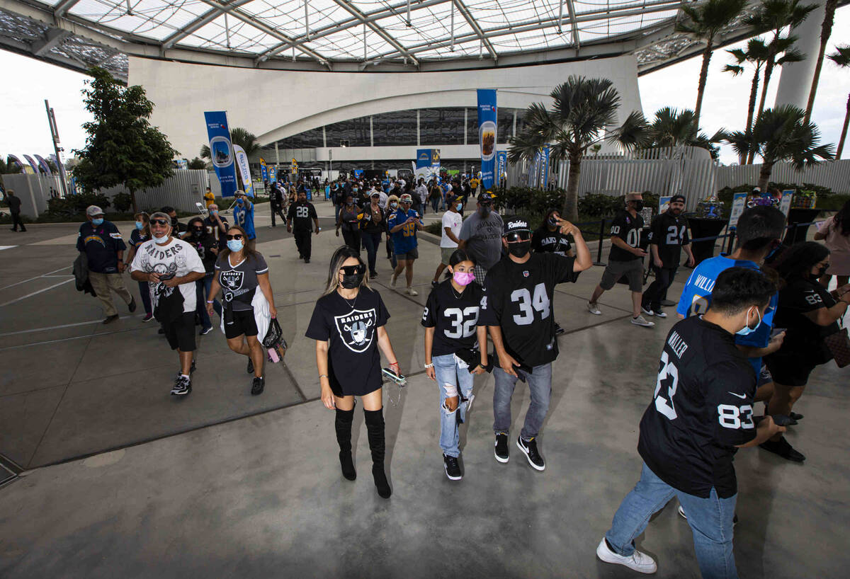 Raiders fans walk around SoFi Stadium before the start of an NFL game against the Los Angeles C ...