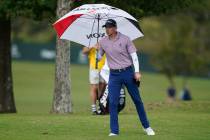 Jared Wolfe steps out with his umbrella as rain begins to fall during the first round of the Sa ...