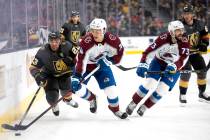 Golden Knights defenseman Alec Martinez (23) and Avalanche right wing Alex Beaucage (74) skate ...