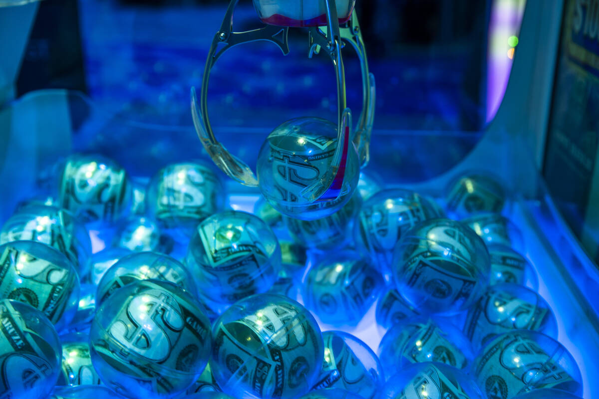 A money ball is grabbed by a claw in an electronic game within the Aruze Gaming display area du ...