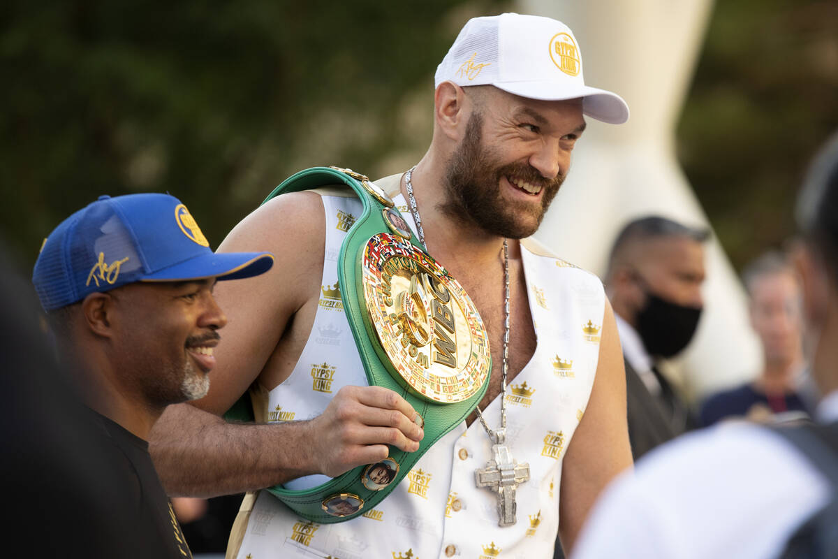 WBC heavyweight champion Tyson Fury poses for photos with trainer Sugar Hill after a press conf ...