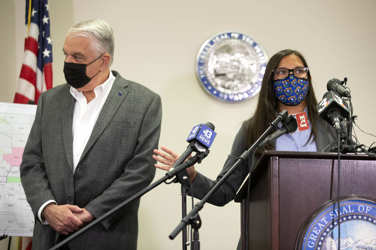 Gov. Steve Sisolak stands next to Incident Commander Sharon Luce during a press conference abou ...