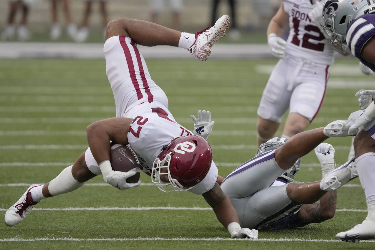 Oklahoma tight end Jeremiah Hall (27) is knocked down by Kansas State defensive back Jahron McP ...
