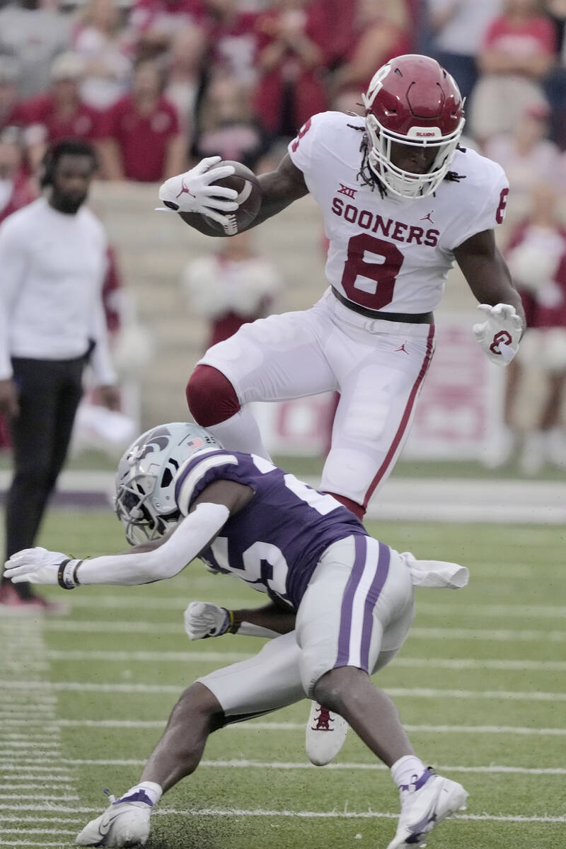 Oklahoma wide receiver Michael Woods II (8) attempts to leap over Kansas State defensive back E ...