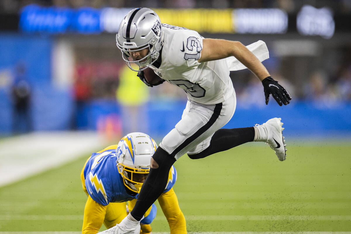Raiders wide receiver Hunter Renfrow (13) fights for extra yardage past Los Angeles Chargers co ...