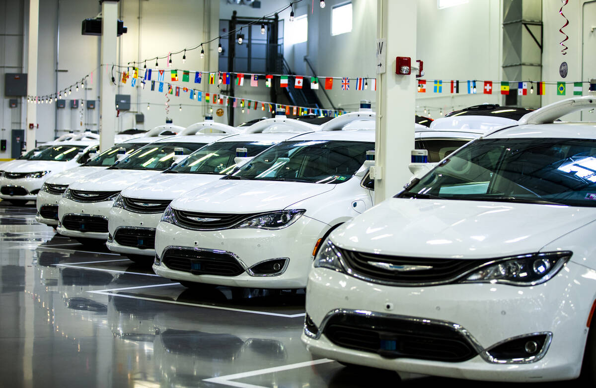 Modified Pacificas are parked in the open warehouse within the Motional autonomous vehicle head ...