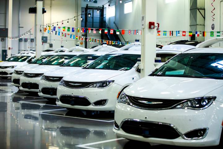 Modified Pacificas are parked in the open warehouse within the Motional autonomous vehicle head ...