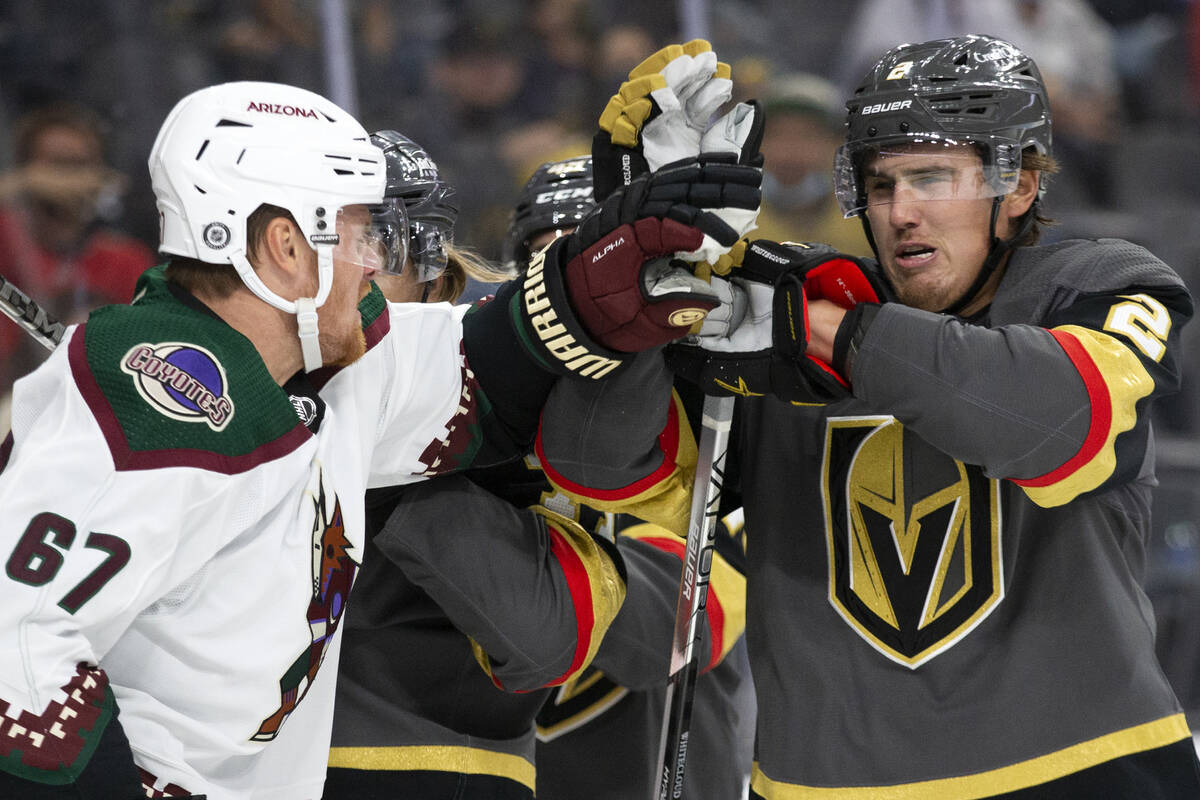 Golden Knights defenseman Zach Whitecloud (2) blocks a punch from Coyotes left wing Lawson Crou ...