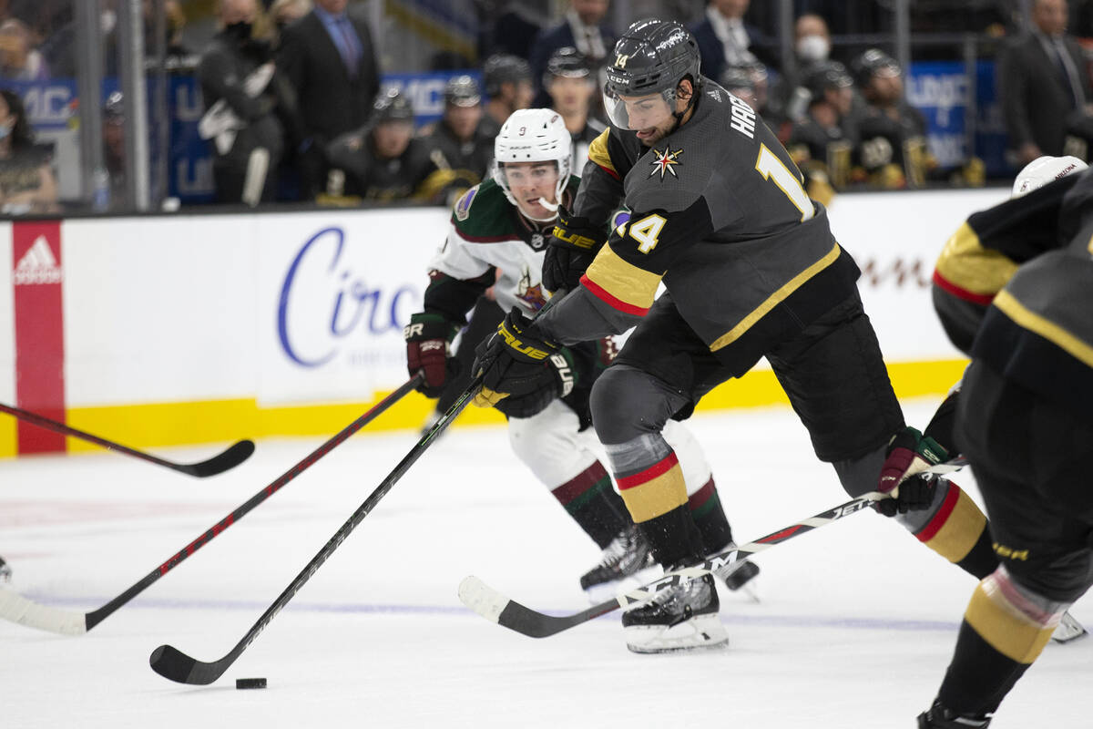 Golden Knights defenseman Nicolas Hague (14) and Coyotes right wing Clayton Keller (9) skate fo ...