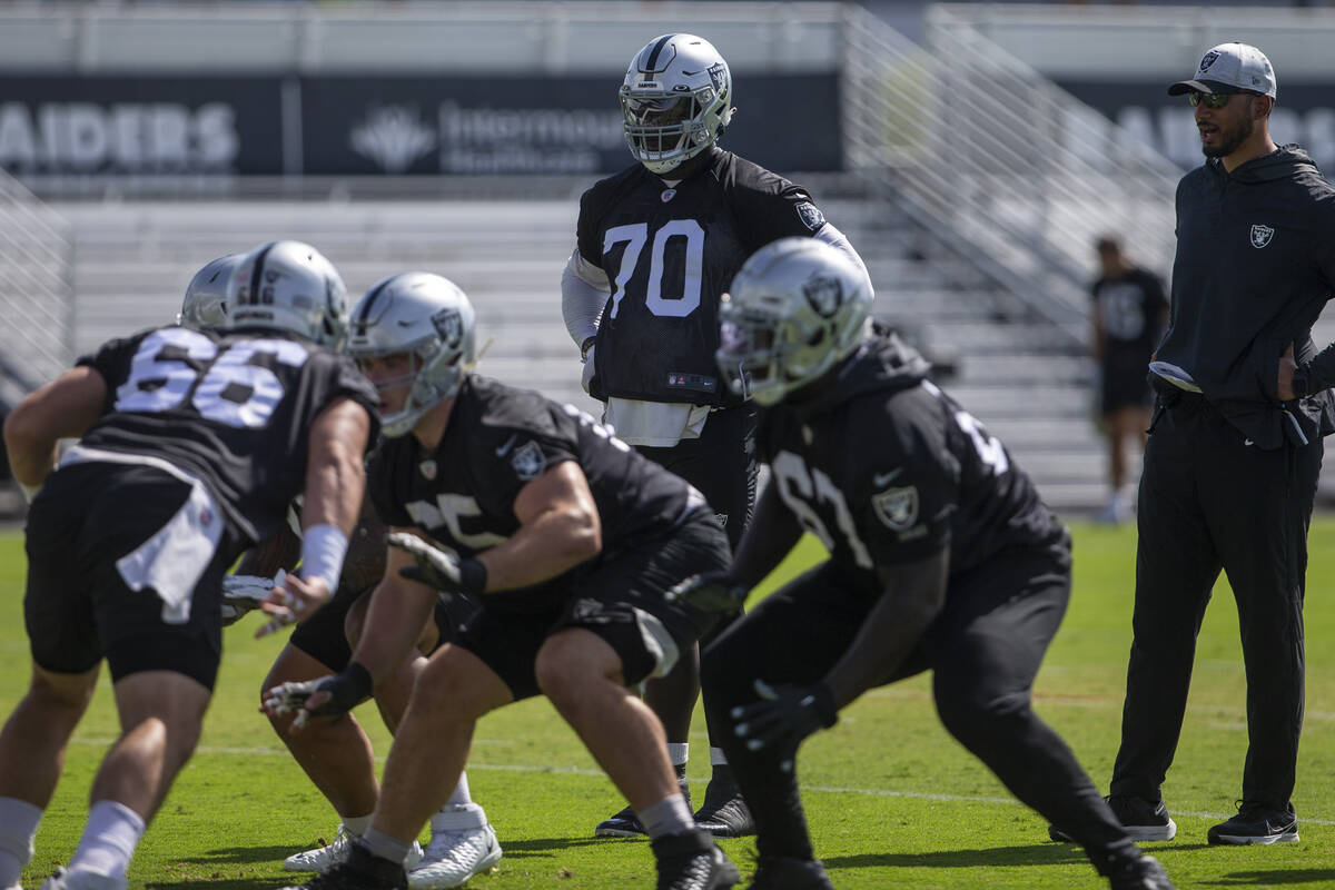 Raiders offensive tackle Alex Leatherwood (70) looks on as the offensive linemen drill during a ...