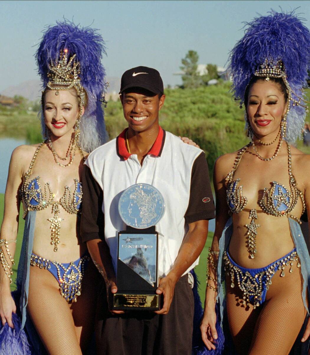 FILE - In this Oct. 6, 1996, file photo, Tiger Woods, center, poses with Ballys' Jubilee dancer ...
